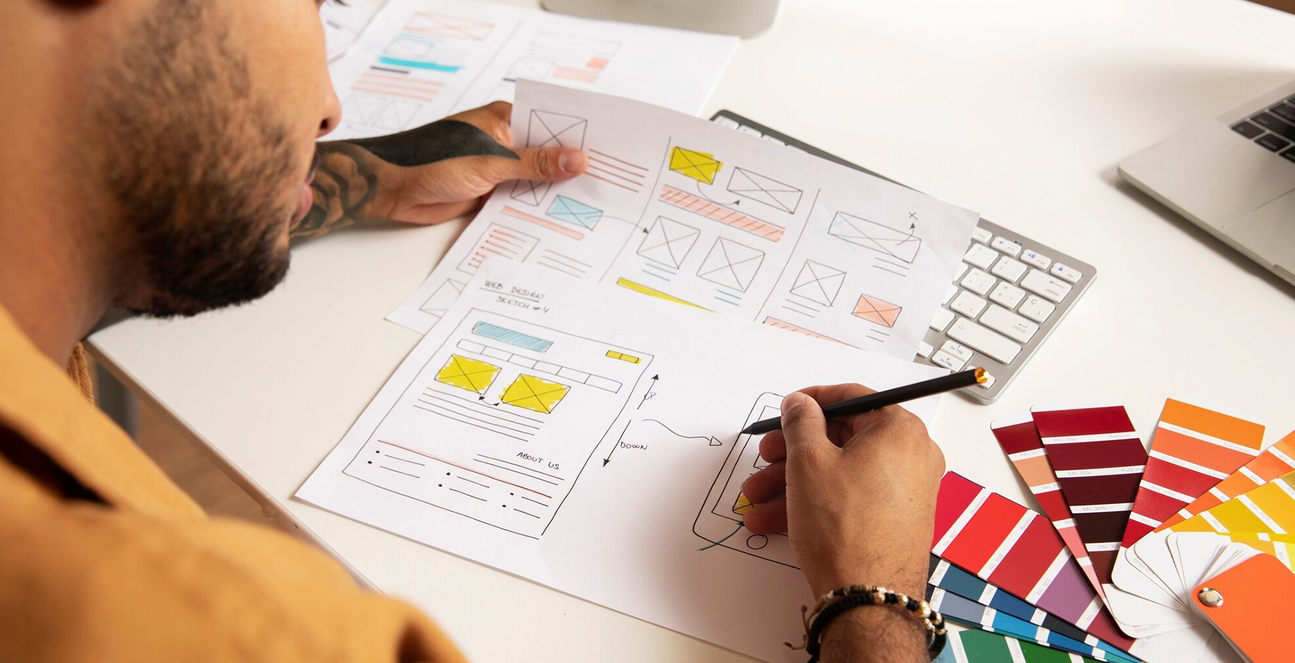 UI/UX designer creating website wireframes and mobile app interface prototypes with color palette samples